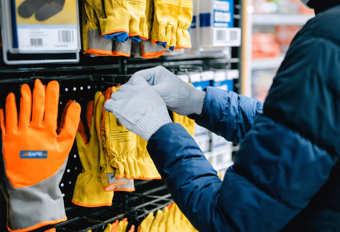 Persona eligiendo guantes de trabajo en una tienda especializada