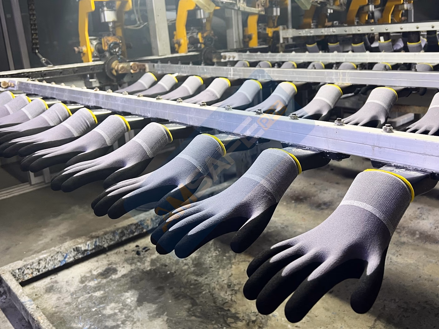 Guantes con recubrimiento de nitrilo avanzando por la línea de producción